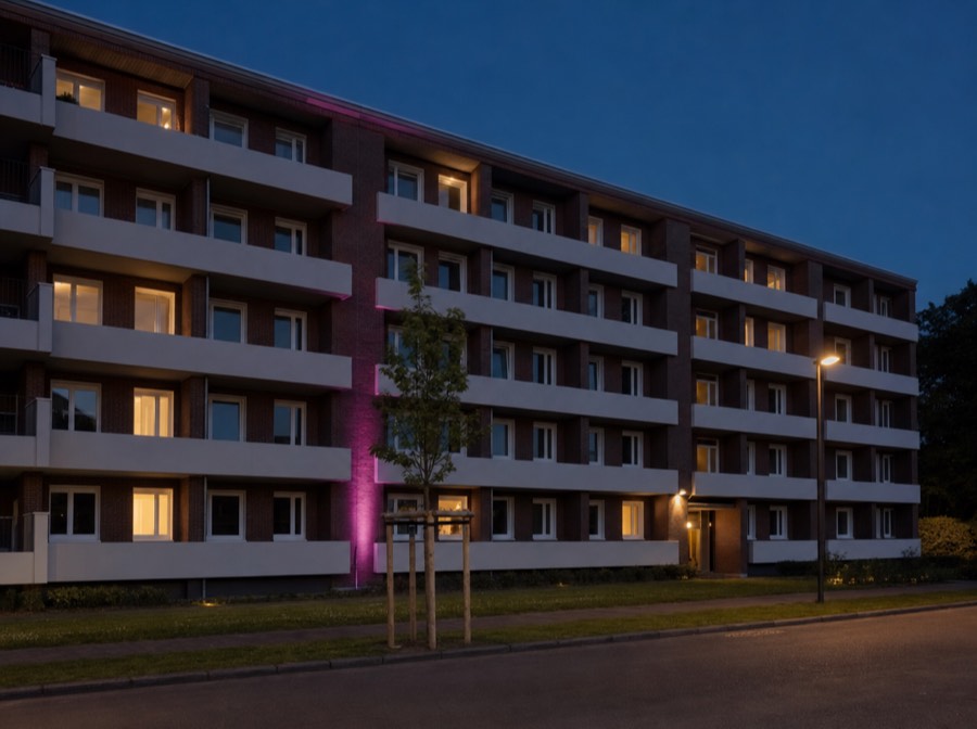 Beispielmotiv: sanierter Backstein-Wohnblock der 1960er Jahre am Abend
